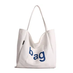 Grand sac cabas blanc en toile avec lettrage bleu et étiquette mode minimaliste
