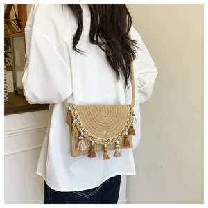 Detail of woven saddle bag with ethnic embroidery, fringe charms and magnetic closure