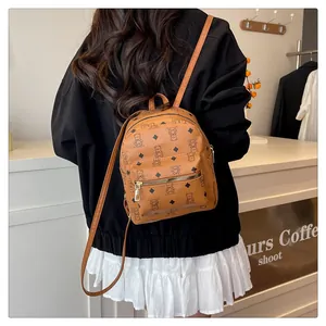Détail d'un mini sac à dos en cuir PU marron avec motif d'ours porté par un modèle