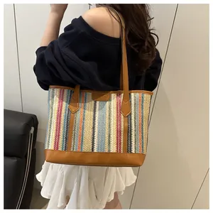 Détail du grand sac cabas tissé avec rayures colorées et poignées en cuir marron élégantes
