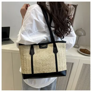 Gros plan du grand sac cabas en paille avec lanières en cuir noir et logo tendance