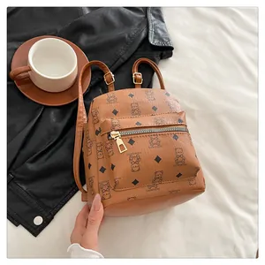 Détail d'un mini sac à dos en cuir PU marron avec imprimés d'ours et boucles dorées