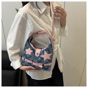 Dettaglio della borsa a spalla in denim Y2K con stelle rosa e bordi sfrangiati rifiniti
