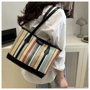 Détail du sac cabas tissé à rayures colorées avec bandoulières et écusson en cuir noir
