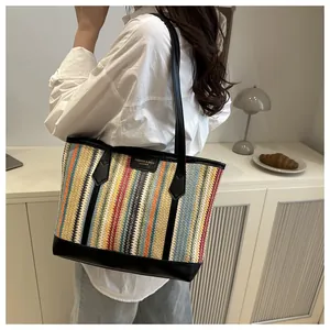 Détail du sac cabas tissé à rayures colorées avec anses en cuir noir et étiquette