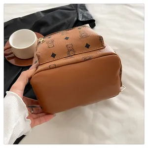 Détail du mini sac à dos marron avec imprimé ours et texture de cuir PU grainé