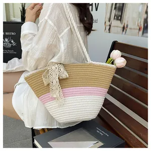 Detail of color-block woven tote with lace bow and thick rope handle in outdoor setting