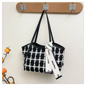 Details von Tweed-Stoff-Tasche mit Lederriemen und dekorativem bedrucktem Band