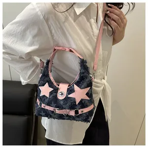 Dettaglio della borsa a spalla in denim Y2K con stella rosa e fibbia metallica