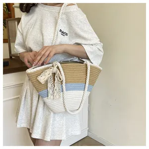 Detail of woven tote bag featuring tricolor patchwork and a beige lace bow decoration