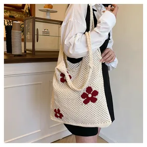 Nahaufnahme beige Häkeltasche mit roten Blumenstickereien und Netzstruktur Details