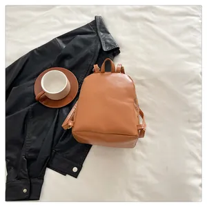 Gros plan d'un mini sac à dos en cuir PU marron avec motif monogramme classique sur fond blanc