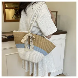 Detail of a woven tote bag featuring tricolor stripes and a delicate lace bow accent