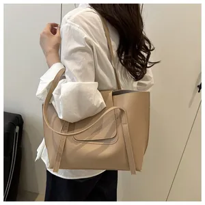 Detailed view of beige faux leather tote bag with round stitching on magnetic flap