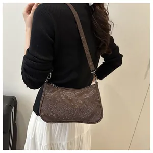 Detail of trendy brown snake skin textured shoulder bag worn by model in minimalist studio