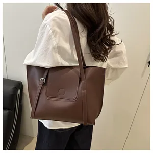 Detail of dark brown tote bag showing smooth matte PU leather texture and magnetic buckle