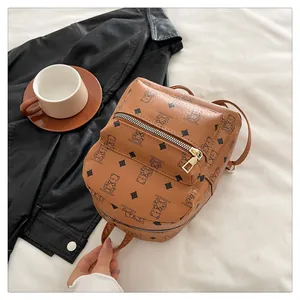 Détail d'un sac à dos en cuir PU marron avec motifs d'ours et fermetures éclair dorées
