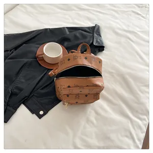Vue détaillée du mini sac à dos marron en cuir avec motifs d'ours et fermetures éclair