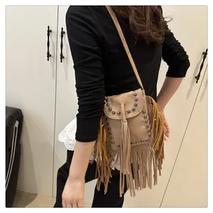 Détail du sac bandoulière beige avec clous argentés et longues franges de style bohème
