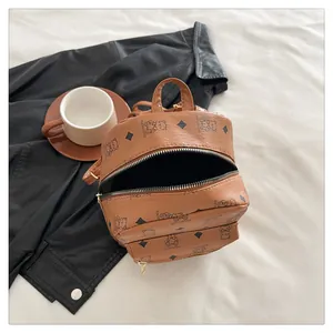 Détail d'un mini sac à dos en cuir PU imprimé avec motif ours et poche avant zippée