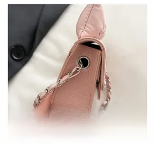 Detailansicht der rosa Tasche mit Litschi-Leder, silberner Öse und Kettenriemen