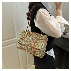 Detailed embroidery on vintage floral crossbody bag with gold chain strap detail