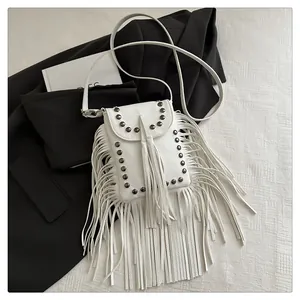 Gros plan sur le sac à bandoulière blanc à franges avec rivets et texture grainée