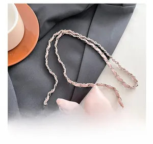 Detail des rosa gesteppten Lederriemens mit geflochtener Goldkette und Lederband