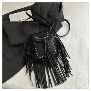 Détail du sac à bandoulière noir à franges avec clous argentés et texture cuir grainé