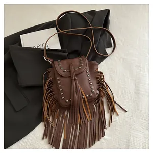 Détail du sac bandoulière bohème marron avec rivets métalliques et longues franges