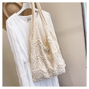 Gros plan du sac cabas tissé avec perles décoratives et détails de maille ajourée