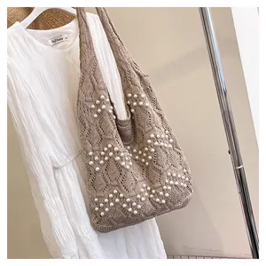 Détail du sac cabas en tricot marron foncé orné de perles artificielles blanches