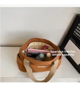 Interno della borsa tote in tela capiente con tablet e oggetti di uso comune