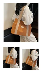 Dettaglio della borsa tote in tela caramello con tracolla beige e tasche laterali