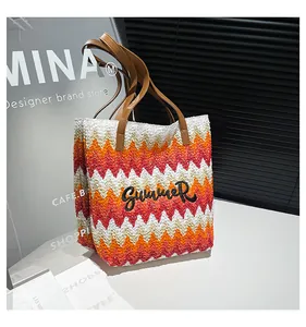 Detail of Summer embroidery on wave patterned straw tote with leather handles