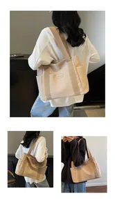 Vista dettagliata di una grande borsa tote beige in tela con spallacci larghi e tasche