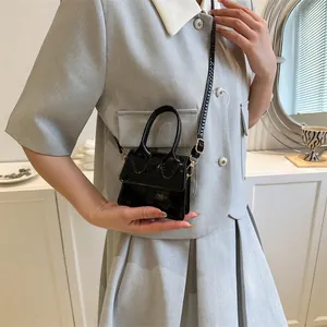 Mini black crocodile embossed glossy handbag with gold hardware and crossbody strap