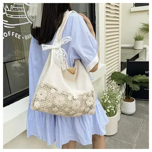 Close-up of canvas tote bag with floral lace hollow stitching and bow details