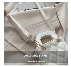 Detail view of the adjustable buckle and quilted texture on white crossbody bag