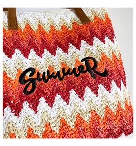 Detail of multi-colored wave pattern woven beach bag with black SUMMER embroidery