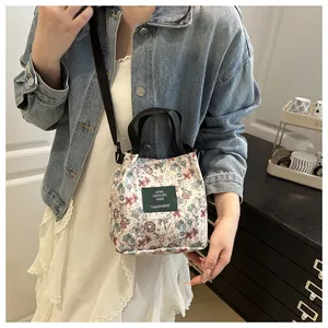 Détail de la broderie florale sur le sac seau en toile avec étiquette vert foncé