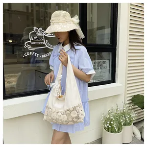 Detail of canvas tote bag with crochet flower patterns and lace bow on the shoulder strap