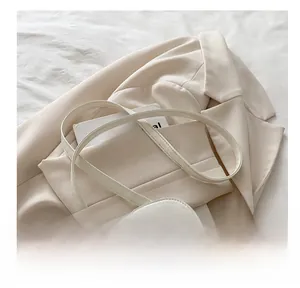 Close-up of a white quilted crossbody bag with soft straps and diamond pattern