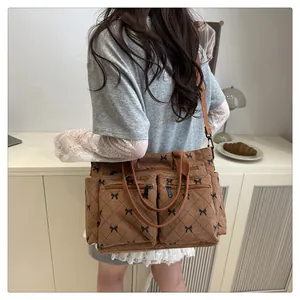 Detail of brown corduroy tote bag featuring black bow diamond patterns and functional pockets