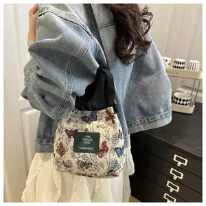 Détail du sac seau ethnique avec broderie papillon et texture jacquard tissée