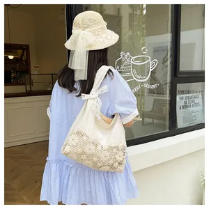Detail of canvas tote bag with floral crochet lace and a delicate ribbon bow accent