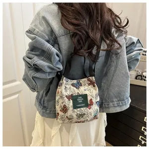 Vue détaillée d'un petit sac seau brodé avec des motifs de papillons colorés au dos