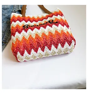 Detail of colorful wave pattern straw tote bag with Summer embroidery and leather handles
