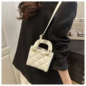Mini sac bandoulière matelassé blanc cassé avec détails dorés porté par un mannequin