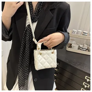 Détail d'un sac à main blanc matelassé avec motif à carreaux et œillets dorés